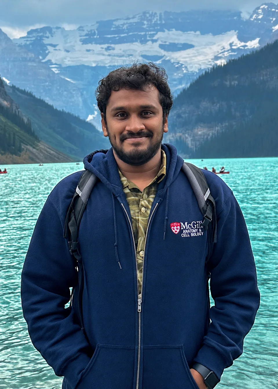 Adwaith B Uday beside a turquoise mountain lake